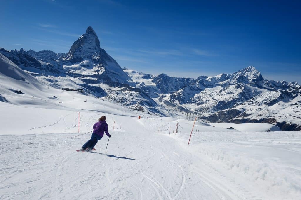 A female skier skiing without a helmet alone on the ski slope